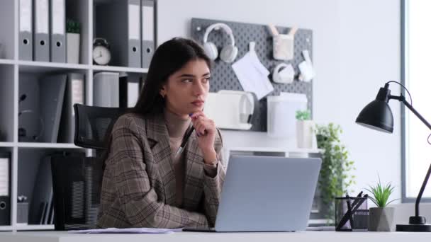 Geconcentreerde blanke zakenvrouw reflecteert op kantoor tijdens het werken met laptop en het hebben van briljante idee, glimlachen en vieren. - Video