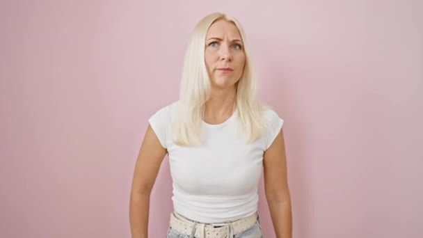 Hullu-hullu nuori blondi nainen seisoo pitkä, huutaa raaka turhautumista - maalattu vaaleanpunainen eristetty tausta kädet esille aggressiivinen huuto - Materiaali, video