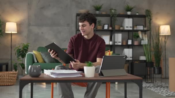 jeden mladý muž kavkazský teenager student učení čtení zatímco sedět doma připravit zkoušku nebo práci na projektu skuteční lidé vzdělávání koncept zpomalení - Záběry, video
