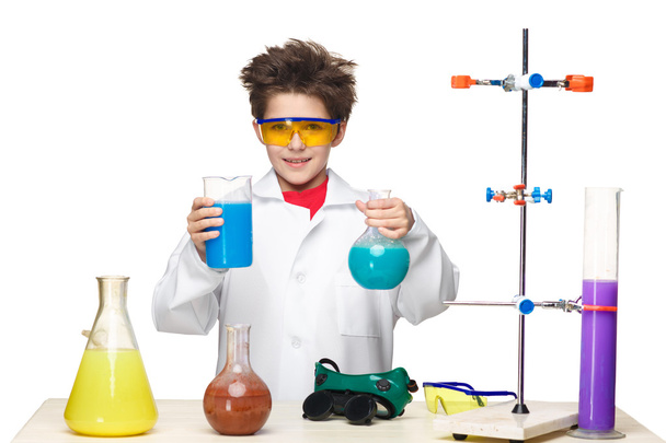Little boy as chemist doing experiment with chemical fluid in the laboratory - Foto, afbeelding