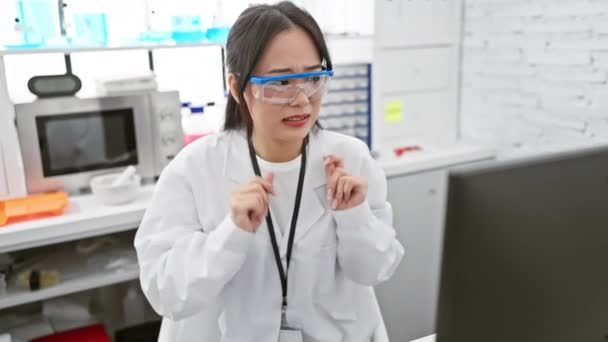 Paura giovane scienziata cinese, scontenta, ha un'espressione disgustata in laboratorio. mani sollevate in avversione, la sua reazione dispiaciuta dipinge disgusto sul suo viso. - Filmati, video