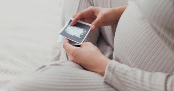 Концепция беременности радость женщина держит свои ультразвуковые изображения, глядя на них с удивлением и волнением для новой жизни растет внутри нее. - Кадры, видео
