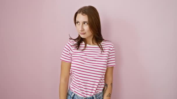 Sch! Bezauberndes junges brünettes Mädchen in gestreiftem T-Shirt, gestikulierend zum Schweigen, Finger über Lippen in einem "Schweigen" -Zeichen. sie strahlt eine entspannte Zuversicht auf einer isolierten rosa Hintergrundwand aus. - Filmmaterial, Video