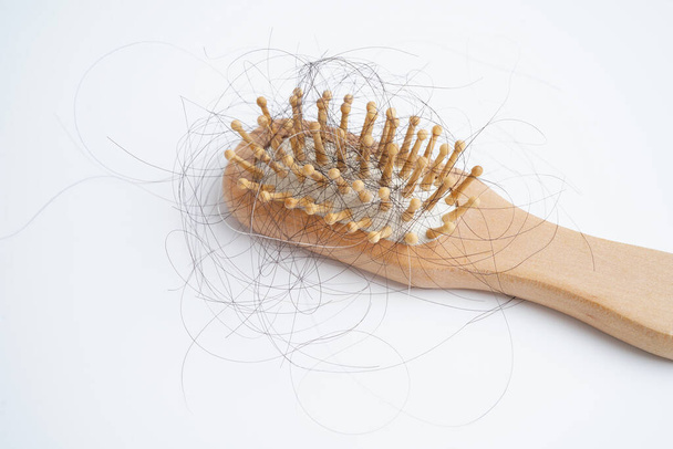 Asian woman have problem with long hair loss attach to comb brush. - 写真・画像