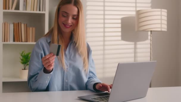 Ικανοποιημένος gen z Καυκάσιος κορίτσι πιστωτική κάρτα κάτοχος laptop online app για να πληρώσει να αγοράσει στο διαδίκτυο υπηρεσίες παραγγελία των καταναλωτών ηλεκτρονικού εμπορίου ιστοσελίδες από το γραφείο στο σπίτι. Ευτυχισμένη γυναίκα κάνει ασφαλή συναλλαγή στο ebank - Πλάνα, βίντεο