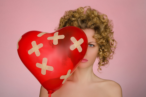 upset woman with ball in shape of heart - Foto, Bild