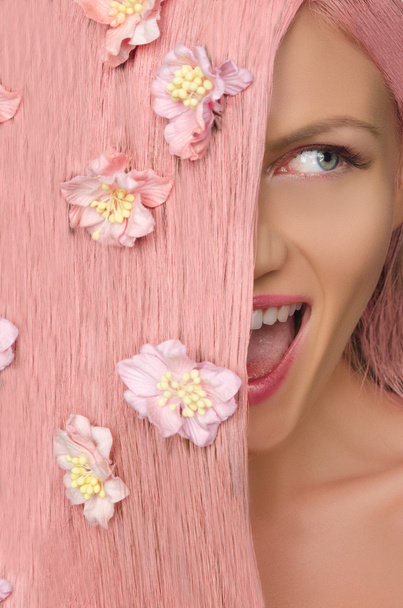woman with pink hair and flowers looking to side - Foto, Imagem