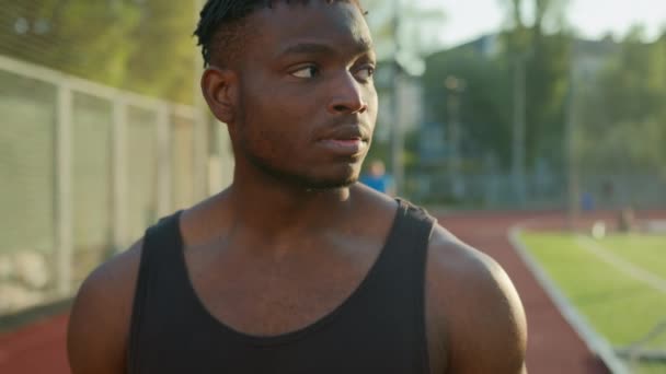 Afrikkalainen amerikkalainen etninen kunto mies urheilu urheilija juoksija lenkkeilijä aamulla stadionilla ulkopuolella terveellistä liikuntaa ulkona katsomassa rannekelloa valmistaudu kilpailuun aloita lenkkeily kaupungin maraton - Materiaali, video