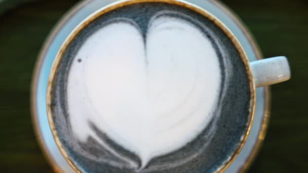Latte matcha azul com espuma de forma de coração em uma caneca de cerâmica - Filmagem, Vídeo