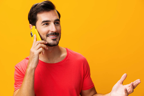 Teknologia mies kopioi muotokuva puhelin eyeglass viestintä avaruus liike mobiili hammas hymy puhelin studio kyberavaruus yllätys osoittaa keltainen hymyilevä älypuhelin viesti onnellinen elämäntapa - Valokuva, kuva