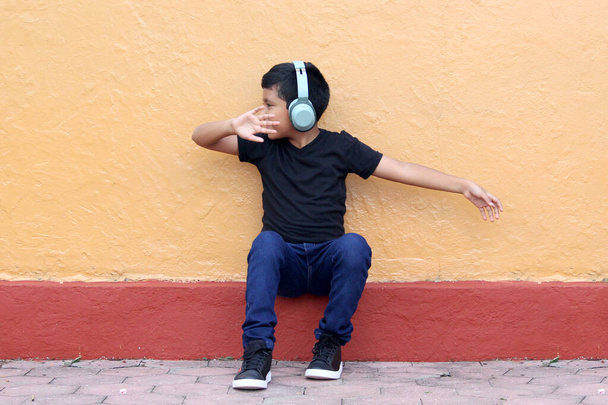 9letý chlapec s tmavou pletí používá naslouchátka, která mění schopnost učení, paměti a retenční schopnosti, vytvářejí sociální izolaci, hypocausii a tinitus - Fotografie, Obrázek