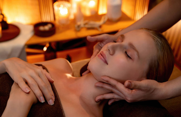 Kavkazská žena si užívá relaxační antistresové masáže hlavy a hýčkání pleti kosmetické rekreace v teplých svíčkách osvětlení okolní salon lázně v luxusním resortu nebo hotelu. Tichý - Fotografie, Obrázek