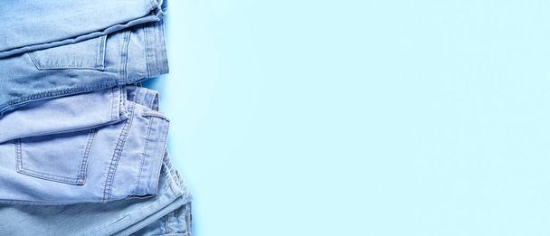 Pantalones vaqueros con estilo sobre fondo azul claro con espacio para texto, vista superior - Foto, Imagen