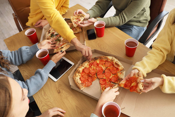 Groupe de jeunes collègues mangeant de la pizza à la fête de bureau, gros plan - Photo, image