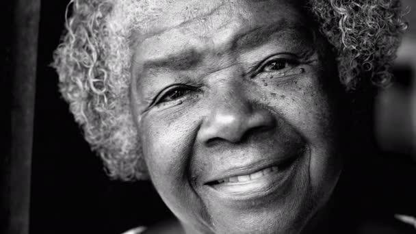 Feliz anciana sudamericana de ascendencia africana sonriendo a la cámara en blanco y negro. Monocromo Retrato de una mujer mayor de 80 años con arrugas y canas - Metraje, vídeo