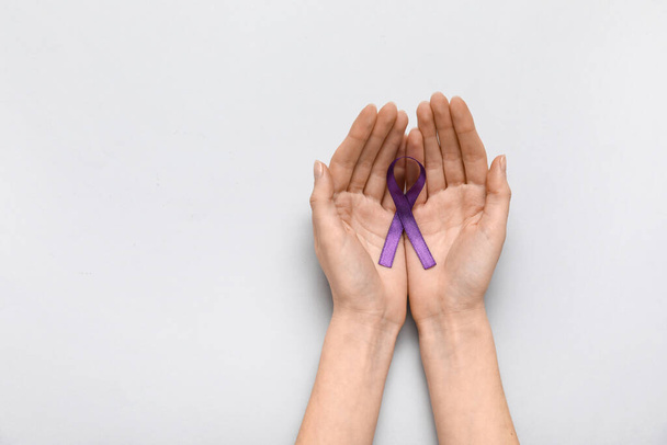 Ženské ruce s fialovou stuhou na šedém pozadí. Koncept rakoviny - Fotografie, Obrázek