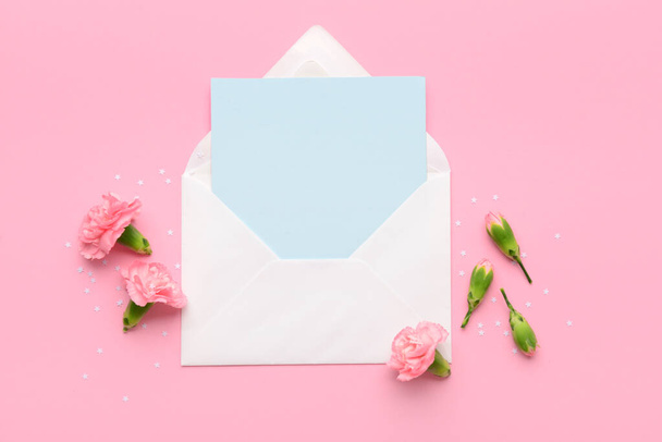 Krásné karafiáty s obálkou a prázdnou kartou na růžovém pozadí. Mezinárodní oslava Dne žen - Fotografie, Obrázek