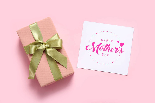 Kaart met tekst HAPPY MOTHER 'S DAY en geschenkdoos op roze achtergrond - Foto, afbeelding
