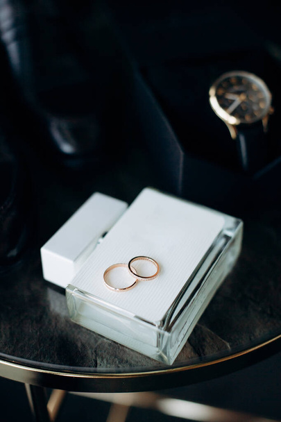a couple of rings on a table with a watch - Photo, Image