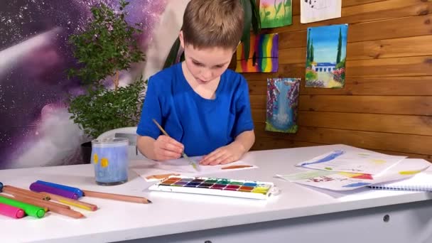 Genç sanatsal ifade, çocukluk hobisi. Tatlı küçük bir çocuk suluboya resim yapar, yaratıcılığını ve hayal gücünü garip çizimler ve kapalı alan bitkileriyle keşfeder. - Video, Çekim