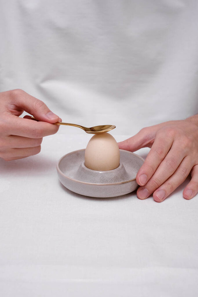 Человек очищает яйцо на стенде крупным планом рук  - Фото, изображение