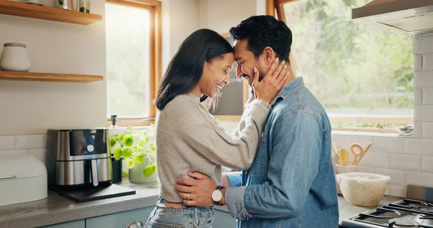 Hug, happy and couple in a kitchen bonding, intimate and talking in their home together with intimacy. Love, face and woman embrace man with smile, care and sharing romantic moment and conversation. - Photo, Image