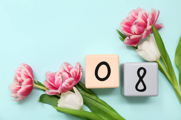 Kalendarz kostki z datą 08 i piękne tulipany na niebieskim tle. Międzynarodowy Dzień Kobiet - Zdjęcie, obraz