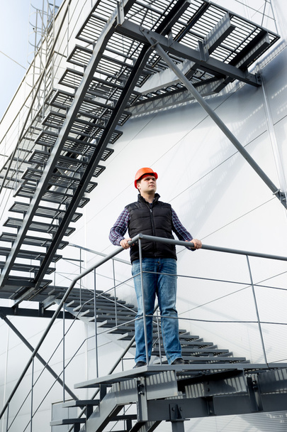 operaio edile in piedi su scale in acciaio in fabbrica
 - Foto, immagini