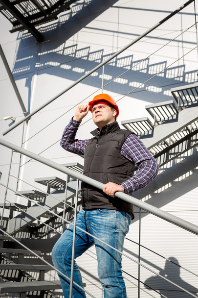male worker in hardhat standing on steel staircase - Foto, Bild