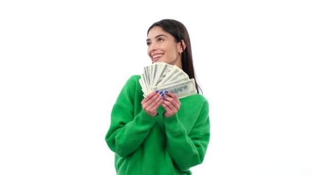 Glückliche junge kaukasische Frau hält einen Stapel Bargeld in der Hand, feiert Preis, Glücksspielgewinn, Gehalt, Jackpot oder Reichtum und lächelt auf weißem Hintergrund. - Filmmaterial, Video