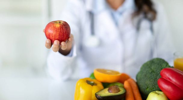 Escritorio nutricionista con frutas y verduras saludables. Dietista trabajando en plan de dieta, mostrando manzana roja orgánica. Pérdida de peso y el concepto de nutrición correcta, banner web, recortado - Foto, imagen