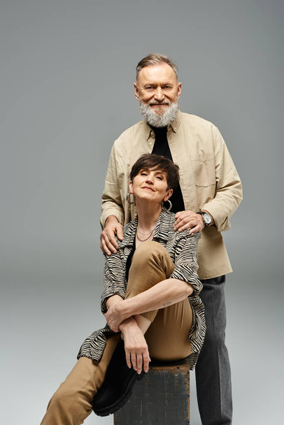 A middle-aged couple in stylish attire striking a pose for a portrait in a studio setting. - Photo, Image