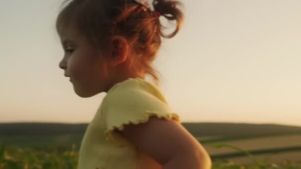 Menina vestindo camiseta amarela andando pelo campo com calos verdes. O conceito de uma infância feliz, rural, vida na aldeia, férias. - Filmagem, Vídeo