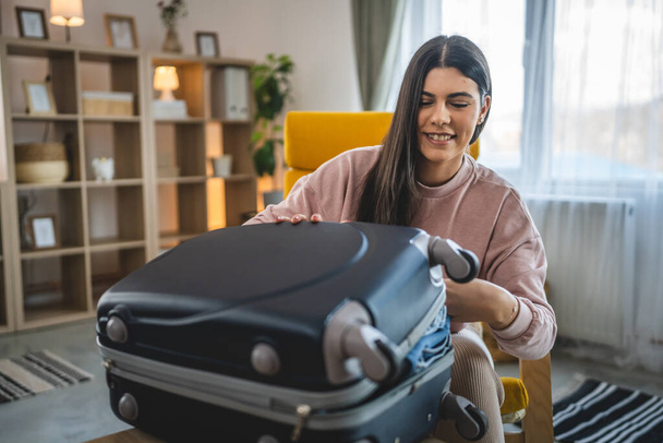 Yksi nainen pakkaa matkalaukku matkatavarat valmistautua loma - Valokuva, kuva