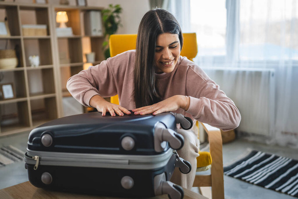 Eine Frau packt Koffer für den Urlaub - Foto, Bild