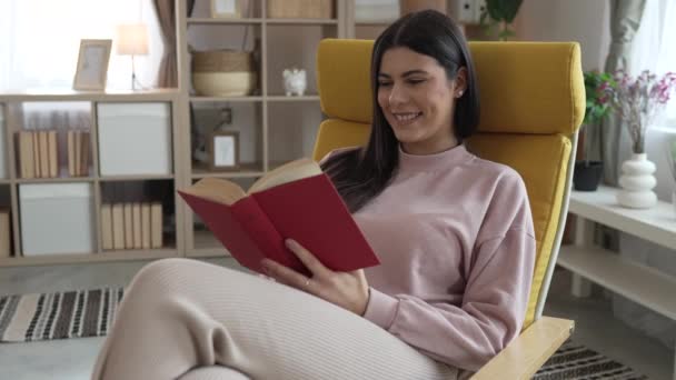 νεαρή ενήλικη γυναίκα ένα θηλυκό διαβάσει βιβλίο ή μελέτη στο σπίτι αργή κίνηση - Πλάνα, βίντεο