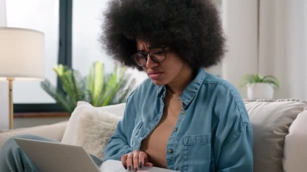 Szomorú feldúlt kudarc aggódik szorongás afro-amerikai nő lány hölgy aggódni szenved elveszett probléma hiba hiba baj laptop online működő számítógép törött rossz hír stressz gépelés pc a kanapén - Felvétel, videó
