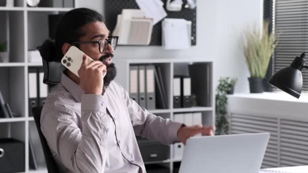 Задоволений і щасливий бізнесмен розмовляє по телефону в офісі. Телефонний дзвінок друзям під час перерви від роботи, позитивних переговорів, онлайн-спілкування. - Кадри, відео