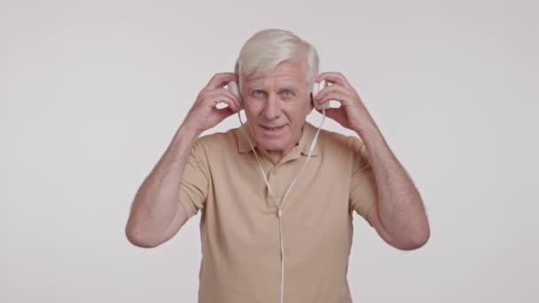 feliz hombre de pelo gris escuchando música en los auriculares. Imágenes de alta calidad 4k - Metraje, vídeo