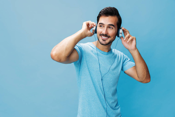 Studio άνθρωπος περικοπή συγκίνηση μιλώντας πορτρέτο τραγουδούν τρόπο ζωής σε απευθείας σύνδεση χώρο μουσική φόντο απολαύσετε διασκέδαση τύπος αντίγραφο μπλε έξω ακουστικά t-shirt ευτυχισμένη - Φωτογραφία, εικόνα