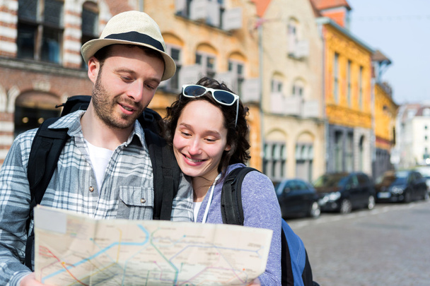 Couple of young attractive tourists watching map  - Foto, Imagem