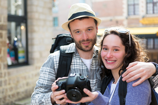 Young couple of tourist watching photographs on camera - Zdjęcie, obraz