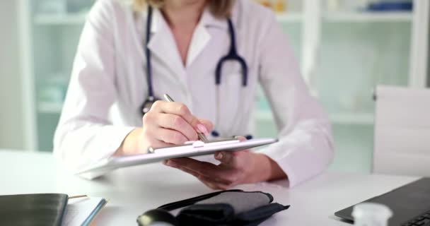 Arts therapeut cardioloog schrijft recept uit aan patiënten in de kliniek. Voorgeschreven behandeling en ziektekostenverzekering - Video