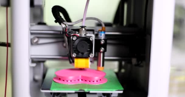 La impresora 3D de modelado de deposición fundida imprime un objeto hecho de plástico. Impresora 3D tridimensional automática hace corazón de plástico - Imágenes, Vídeo