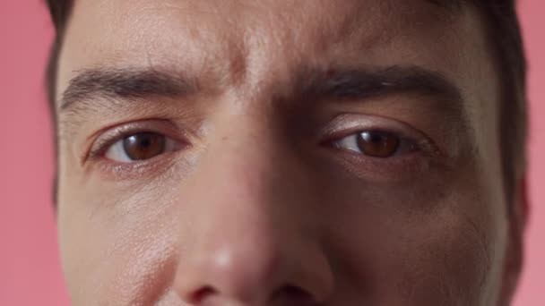 Extreme Nahaufnahme eines Mannes mittleren Alters mit braunen Augen, der in die Kamera blickt - Filmmaterial, Video