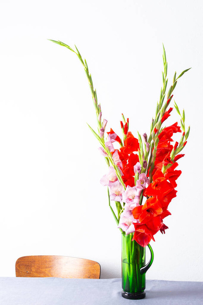 Kırmızı ve menekşe renkli bir buket, çiçeklerle süslenmiş ev dekorasyonu, masanın üzerinde çiçekler olan buket. - Fotoğraf, Görsel
