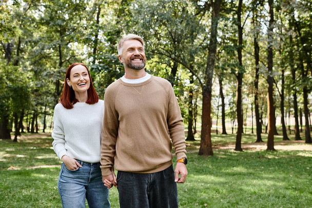 Muž a žena stojí spolu v bujné zelené trávě. - Fotografie, Obrázek