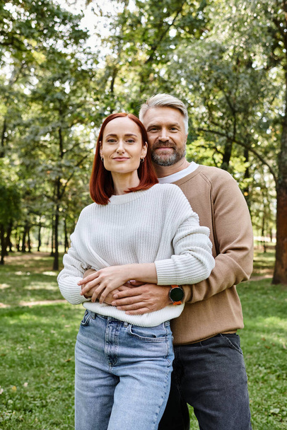 Couple adulte en tenue décontractée debout ensemble dans un parc. - Photo, image