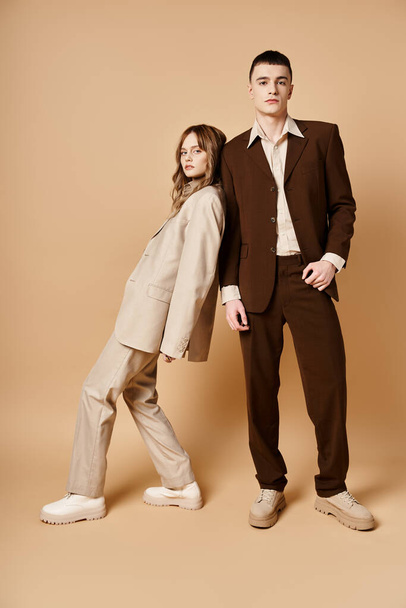 young handsome man in debonair suit posing next to his beautiful girlfriend who looking at camera - Foto, Bild
