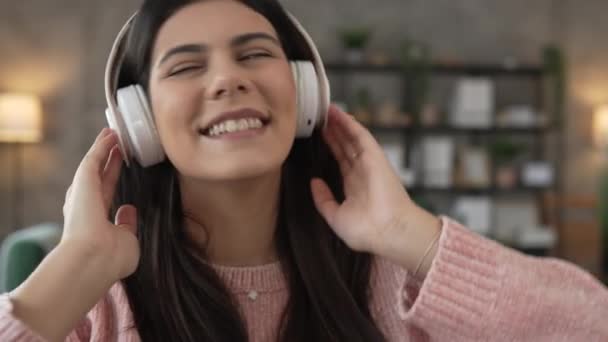 Jedna kaukaska kobieta dorosła kobieta ze słuchawkami używa telefonu komórkowego w domu, aby słuchać muzyki online szczęśliwy uśmiech śpiewać radość bawić się samotnie zwolniony ruch - Materiał filmowy, wideo